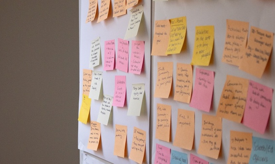 Pink and orange post its on a wall